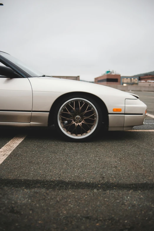 a white car parked in a parking lot, by Christopher Williams, unsplash, photorealism, high detailed wheels, ✨🕌🌙, white gold skin, japanese drift car