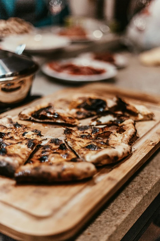 a pizza sitting on top of a wooden cutting board, a portrait, unsplash, smouldering charred timber, chefs table, white, thumbnail