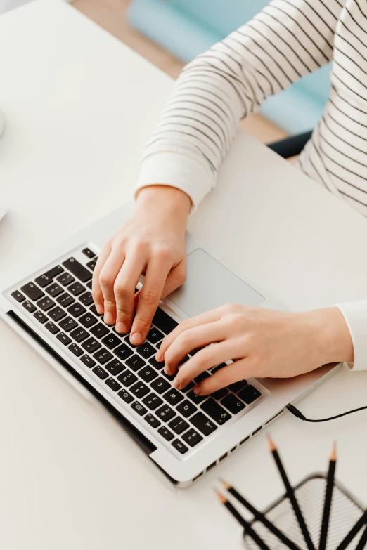 a woman sitting at a desk typing on a laptop, by Carey Morris, trending on pexels, rounded lines, white background, high angle close up shot, multiple stories