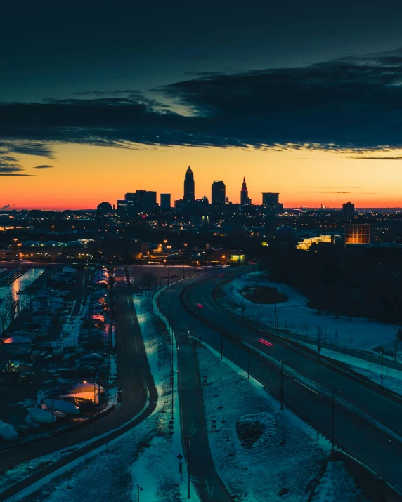 a view of a city from the top of a hill, an album cover, by Carey Morris, unsplash contest winner, cleveland, ☁🌪🌙👩🏾, cold sunset, koyaanisqatsi