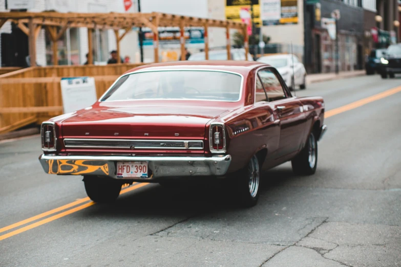 a red car driving down a city street, pexels contest winner, ford, well preserved, back, square