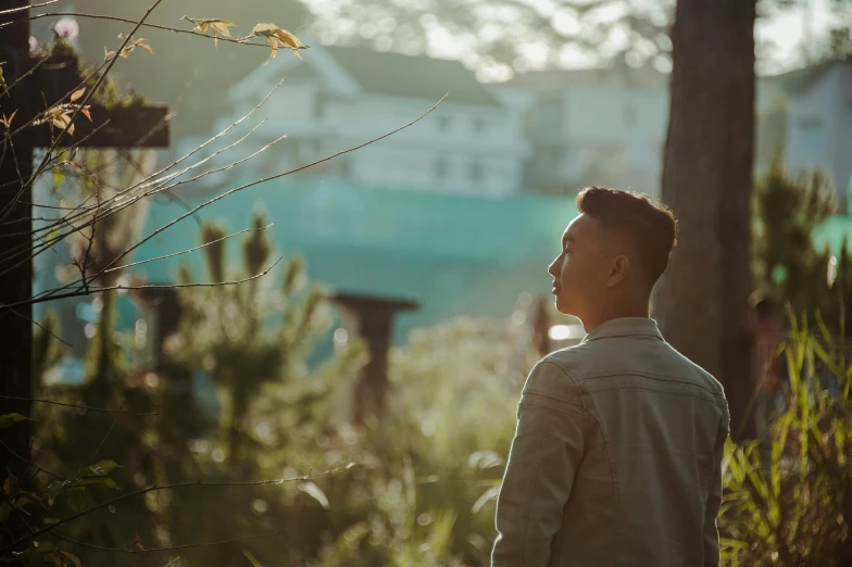 a man that is standing in the grass, pexels contest winner, nice afternoon lighting, asian male, looking out, trees in background