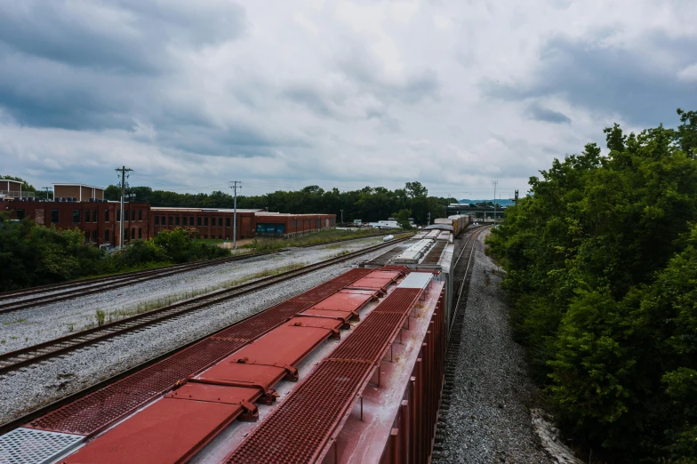 a train traveling down train tracks next to a forest, by Joe Stefanelli, unsplash, photorealism, shot from roofline, chesterfield, trading depots, panoramic