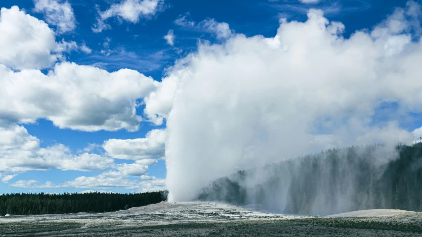 an old - fashioned geyser spewing water from the top of a mountain