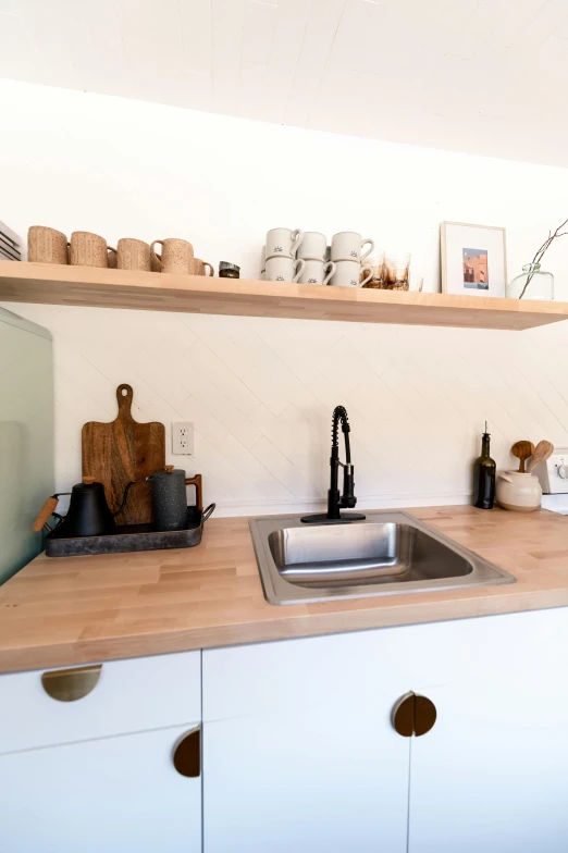 a kitchen with a sink, oven and shelves