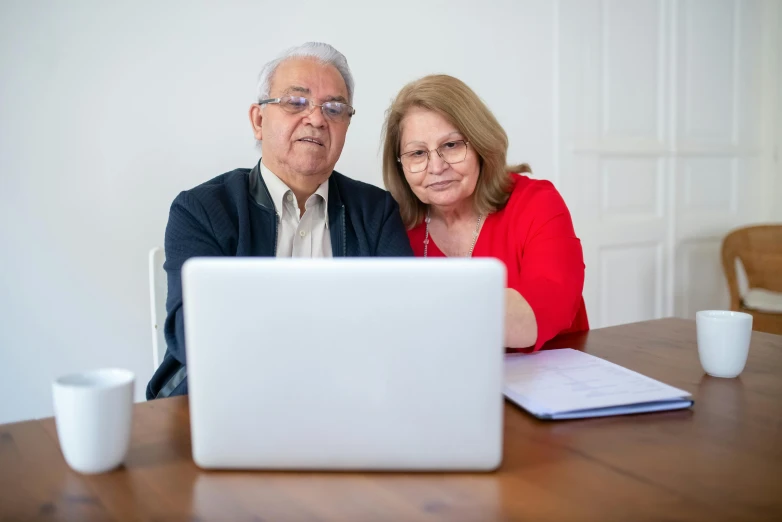 a man and a woman sitting at a table with a laptop, 15081959 21121991 01012000 4k, an elderly, professional shot, thumbnail