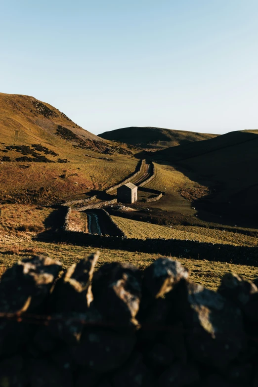 the road stretches out into the distance with a rock fence on either side