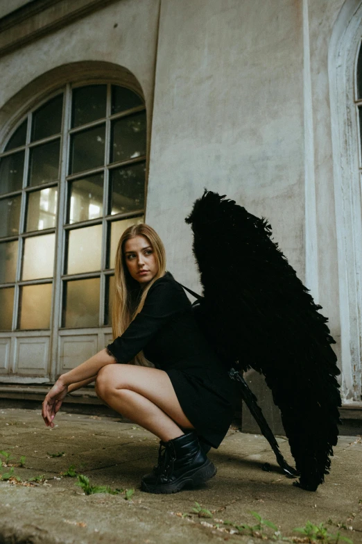 a woman kneeling on the ground with an umbrella, inspired by Elsa Bleda, pexels contest winner, renaissance, villainess has black angel wings, portrait of kim petras, young harpy-girl, gif