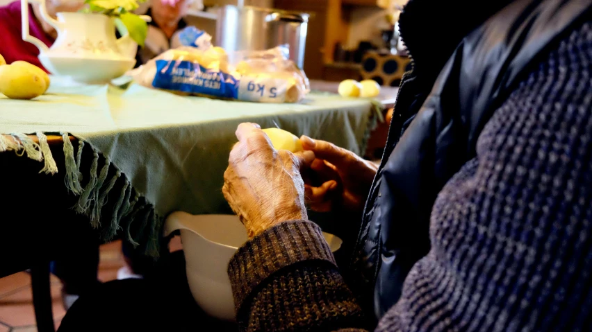 a person sitting at a table with a bowl of food, nursing home, chopping hands, thumbnail, potato