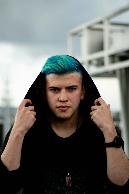 a man with blue hair wearing a black hoodie, unsplash, ((greenish blue tones)), a blond, symmetrical face orelsan, age 2 0