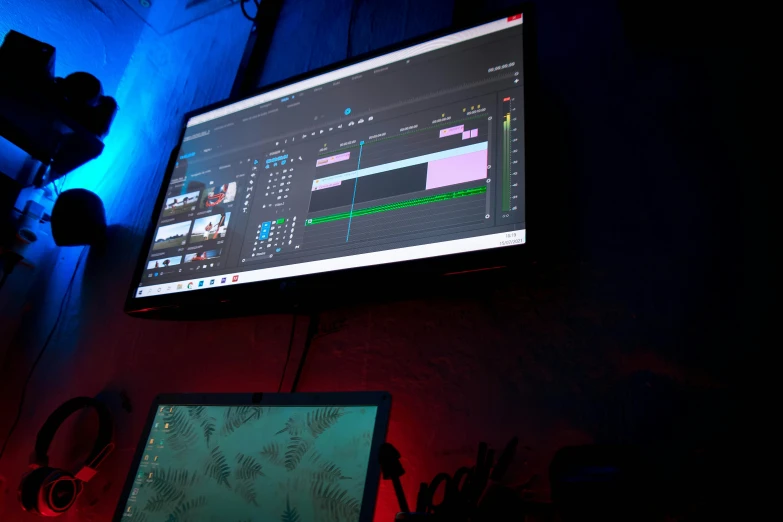 a computer monitor sitting on top of a desk, by Robbie Trevino, pexels, video art, stage at a club, adobe premier pro, blue and red lights, production ig