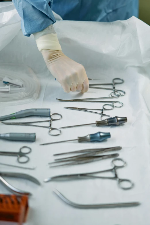 a close up of a bunch of tools on a table, surgical gown and scrubs on, scissors in hand, sterile minimalistic room, multiple stories