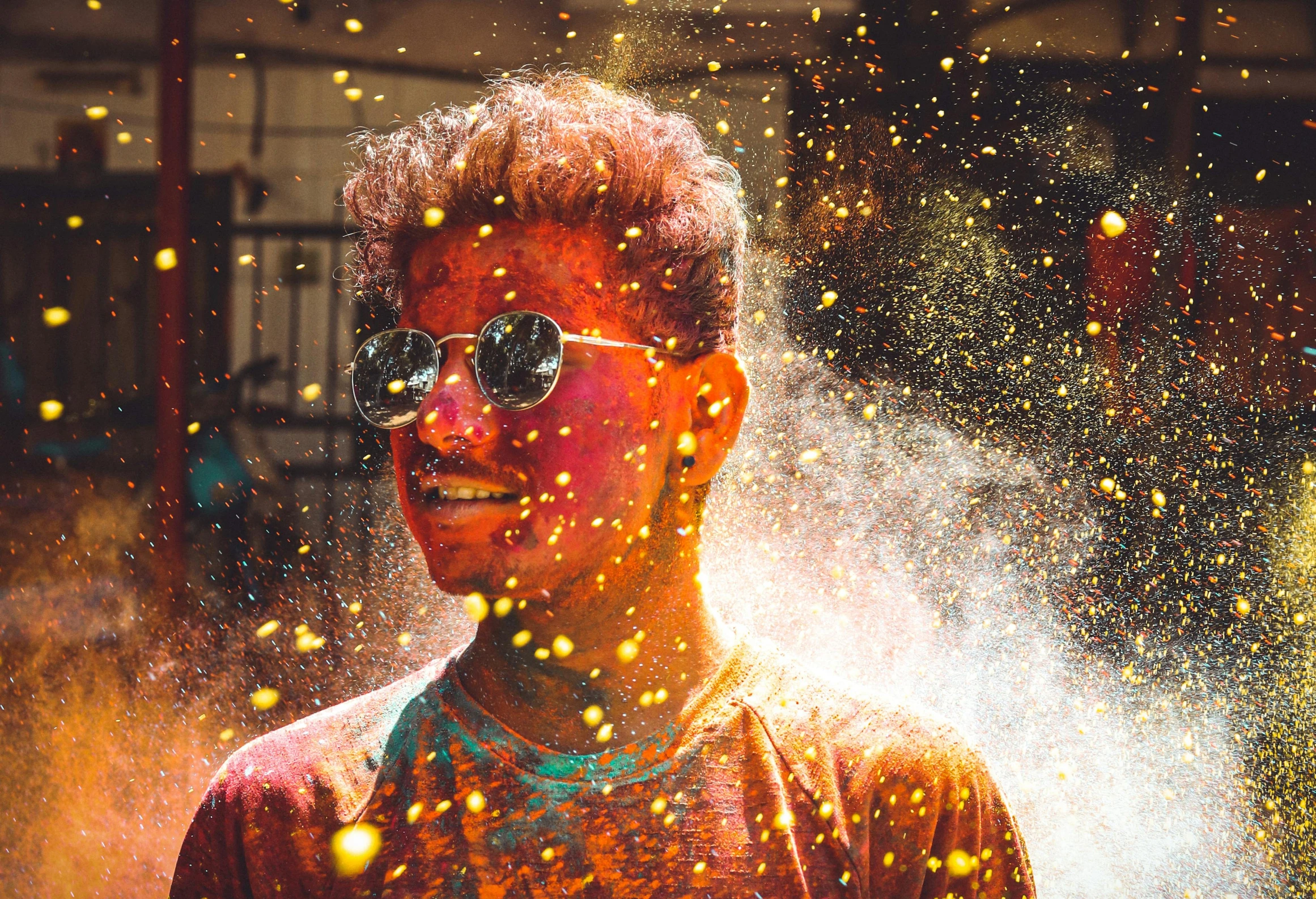 a man with sunglasses and colored powder on his face, a colorized photo, pexels contest winner, fire particles, hindu aesthetic, teenage boy, gold sparks