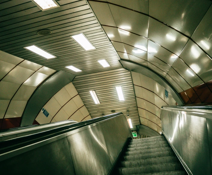 an escalator going down the middle of a tunnel, an album cover, unsplash contest winner, hyperrealism, london underground tube station, fluorescent ceiling lights, inside a brutalist space ship, 2000s photo