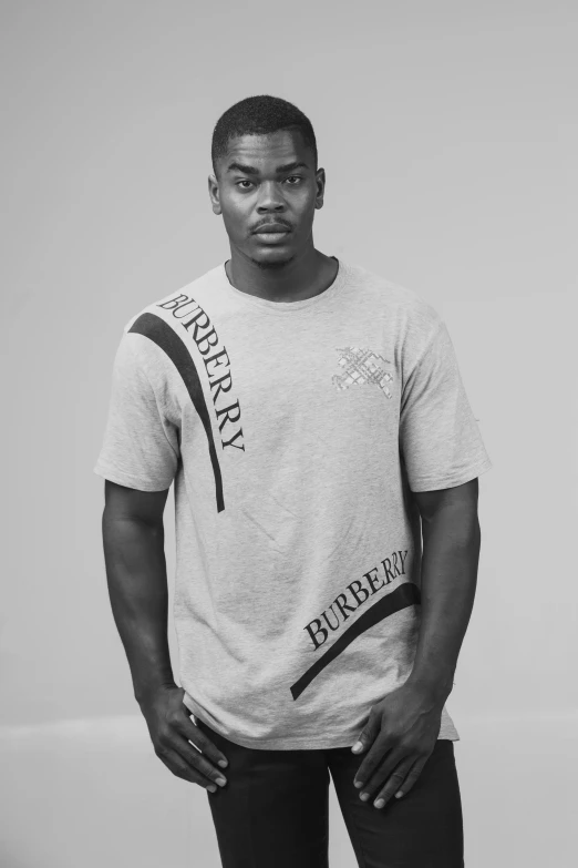 a black and white photo of a man in a t - shirt, inspired by Theo Constanté, burberry, he is about 2 0 years old, reynold brown, on a pale background