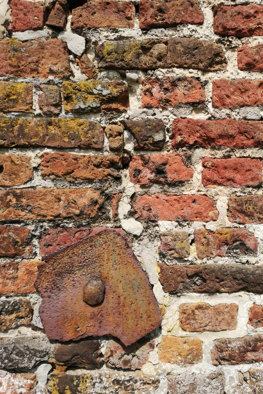 brick wall with rusted paint and a rusted hole