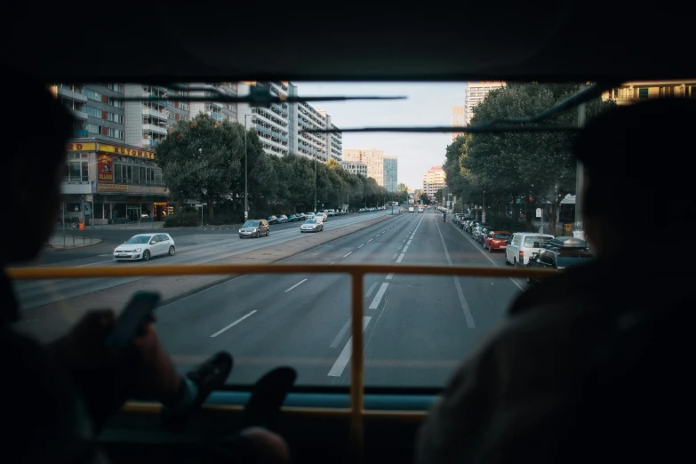 people looking out the windshield of a bus on a city street