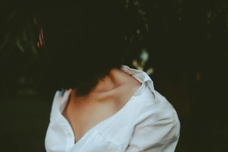 a close up of a person wearing a white shirt, a picture, inspired by Elsa Bleda, trending on pexels, wistful bosom, faceless people dark, brunette woman, broadshouldered