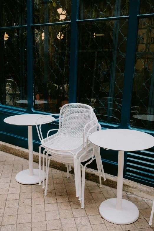 tables and chairs are outside near a window