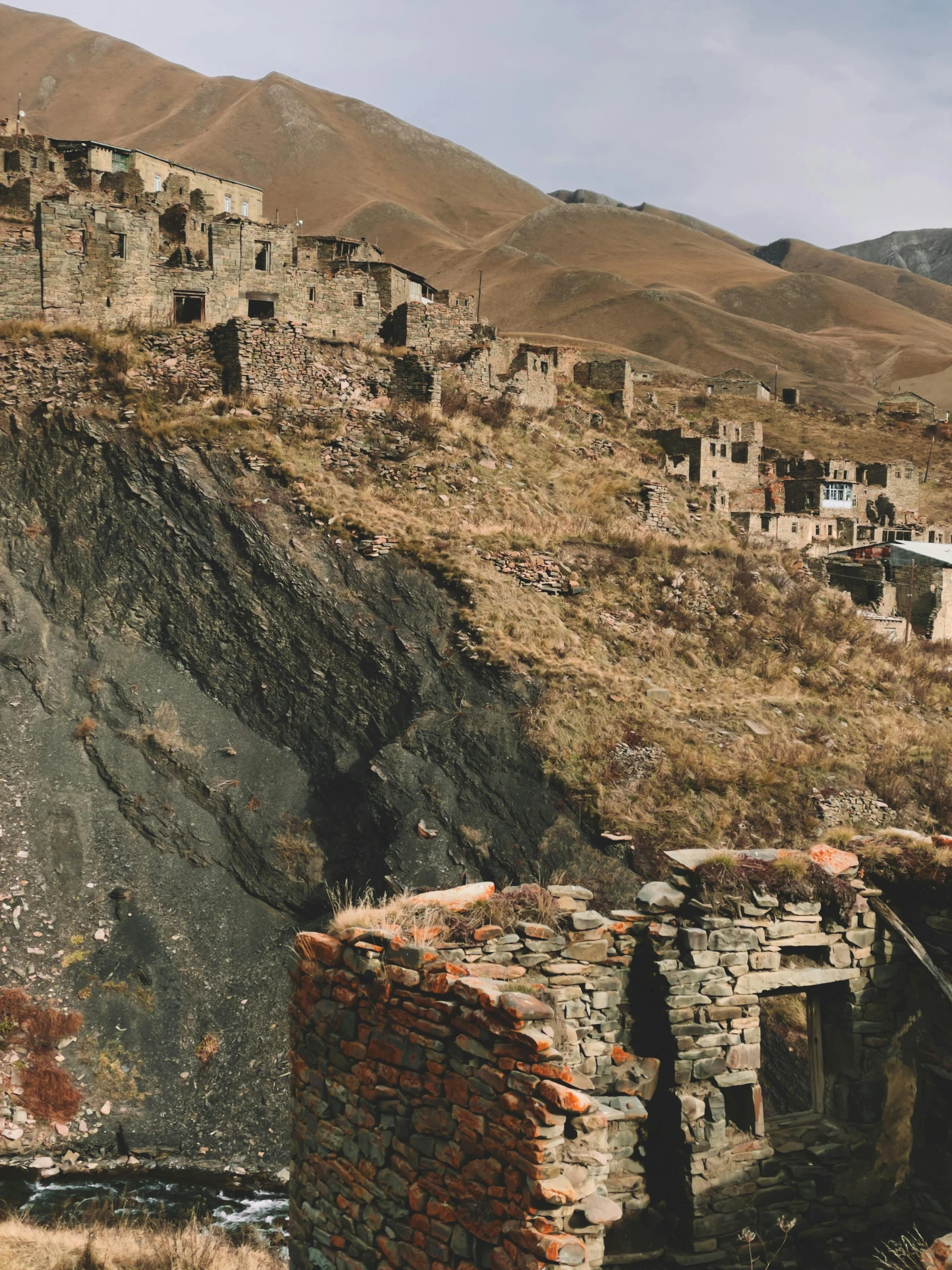 a group of buildings sitting on top of a hill, by Muggur, crumbling masonry, intricate mine, color corrected, slate