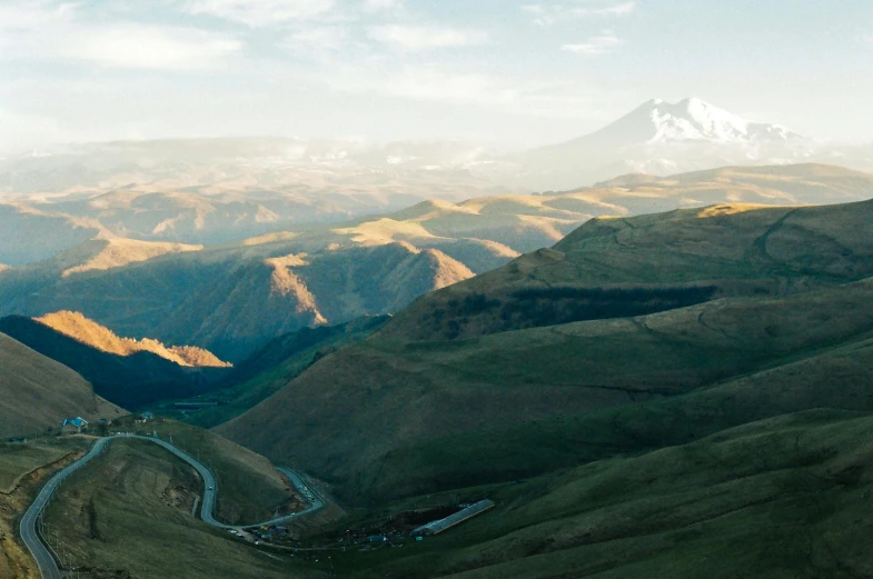 a mountain side road in the mountains with a beautiful blue sky