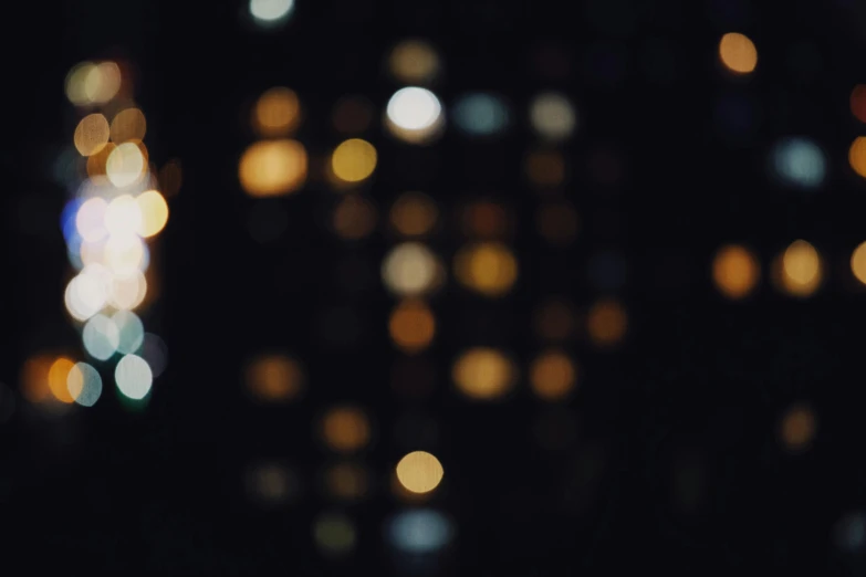 a blurry photo of a city at night, unsplash, light and space, hasselblad film bokeh, slightly pixelated, golden glow, single light