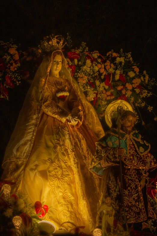 a doll is sitting on a fake bed covered in flowers