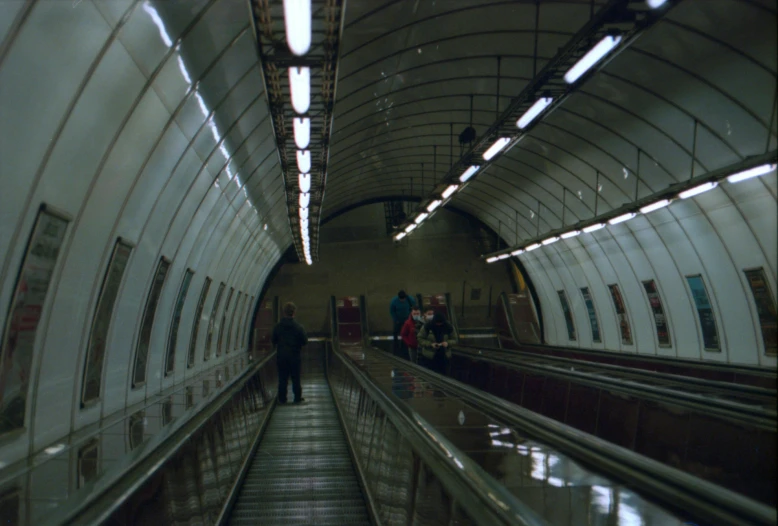 people walking down a very wide metro track