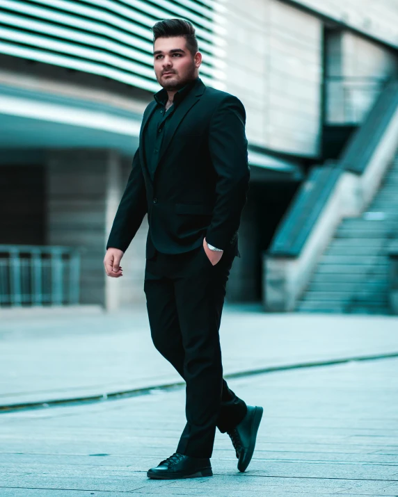 a man wearing a suit and black shoes walking down the sidewalk