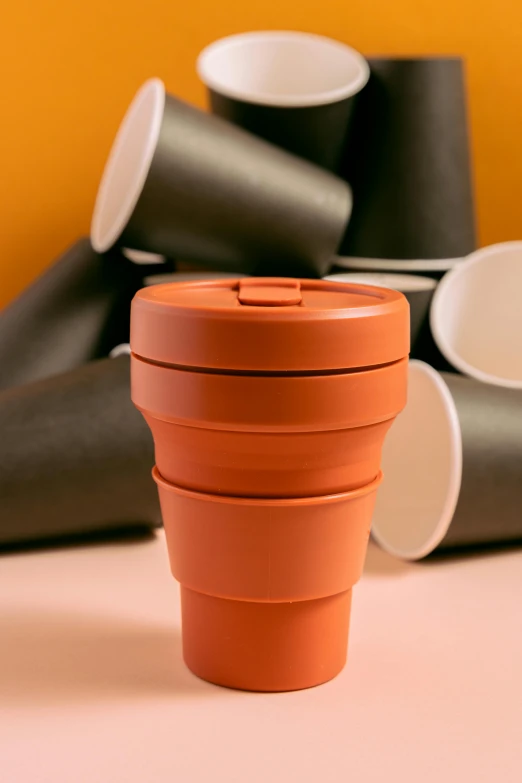 a stack of cups sitting on top of a table, inspired by Christo, unsplash, plasticien, terracotta, medium close up shot, detailed product image, collapsing
