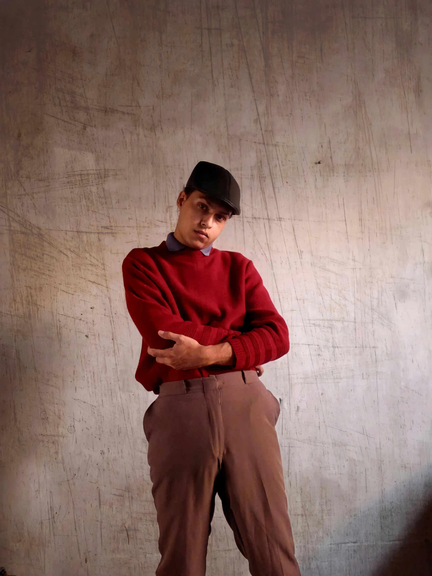 a man in a red sweater and brown pants, by Everett Warner, non binary model, wearing newsboy cap, 1990 photograph, andres rios