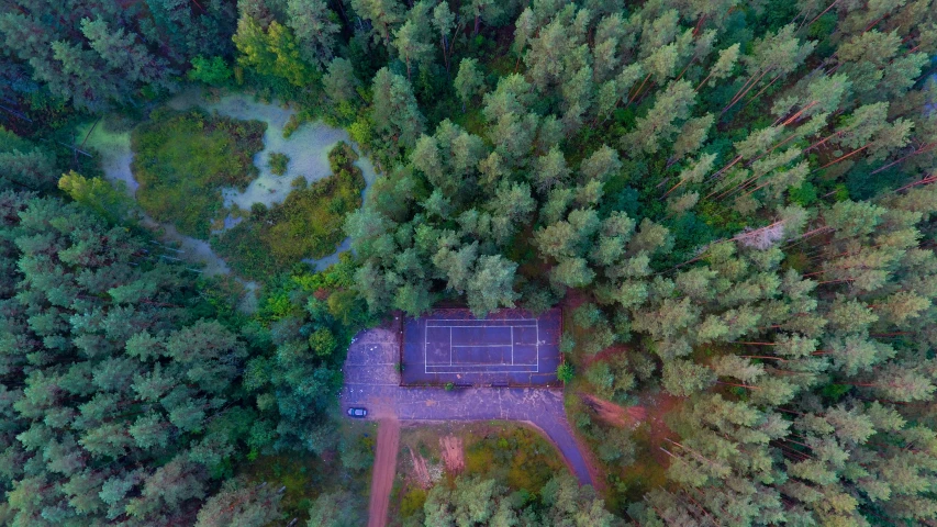 an aerial view of a tennis court surrounded by trees, by Emma Andijewska, unsplash contest winner, realism, evening!! in the forest, cinematic shot ar 9:16 -n 6 -g, dasha taran, forest landscape