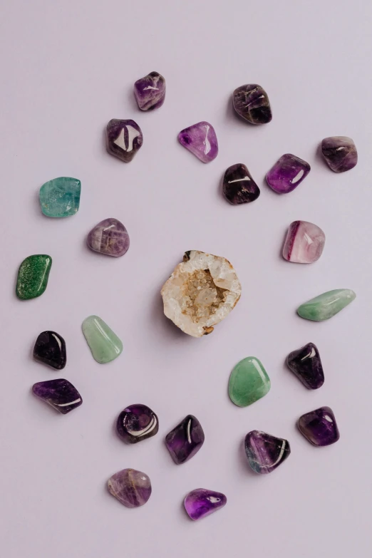 various stones arranged in a circle on a white surface, poster art, trending on pexels, purple and green, made of crystal, jeweled technology, waist up