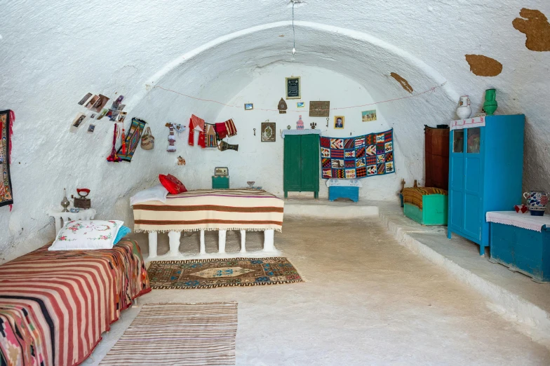 a room with an arched ceiling and colorful carpets on the ground