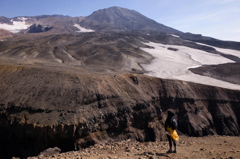 a person stands on top of the mountains