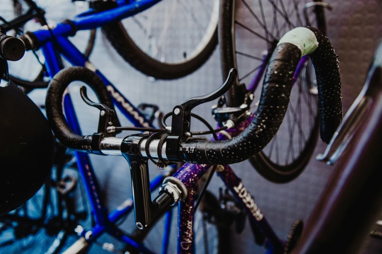 a couple of bikes parked next to each other, by Lee Loughridge, unsplash, black and blue and purple scheme, bottom body close up, levers, sports photo