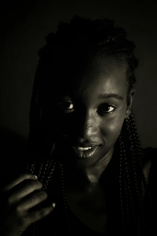 a close up of a person holding a cell phone, a black and white photo, by Chinwe Chukwuogo-Roy, art photography, braided hair. nightime, portrait. 8 k high definition, portrait of ((mischievous)), medium format. soft light