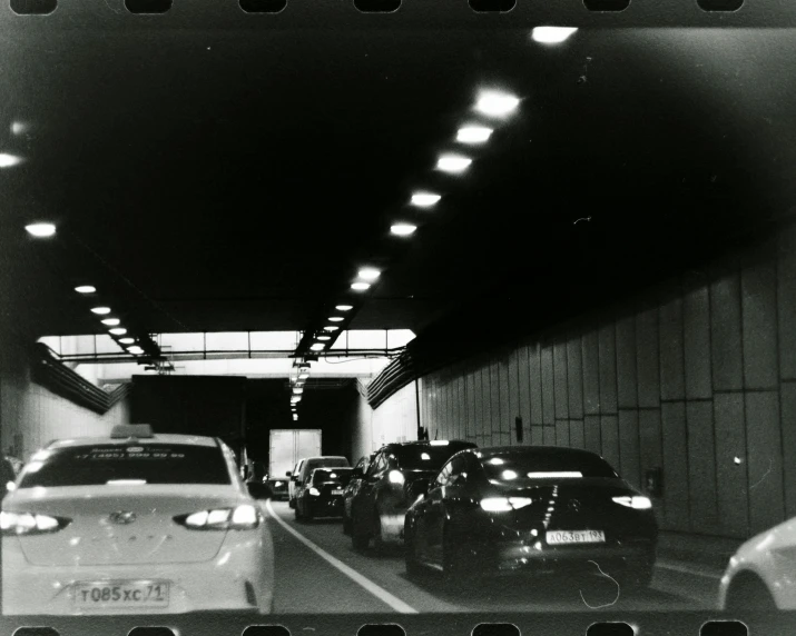 a black and white picture with a lot of cars on a road