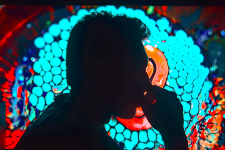 a man talking on a cell phone in front of a stained glass window, a microscopic photo, by Adam Marczyński, pexels, video art, red and blue neon, abstract claymation, eating, profile pic