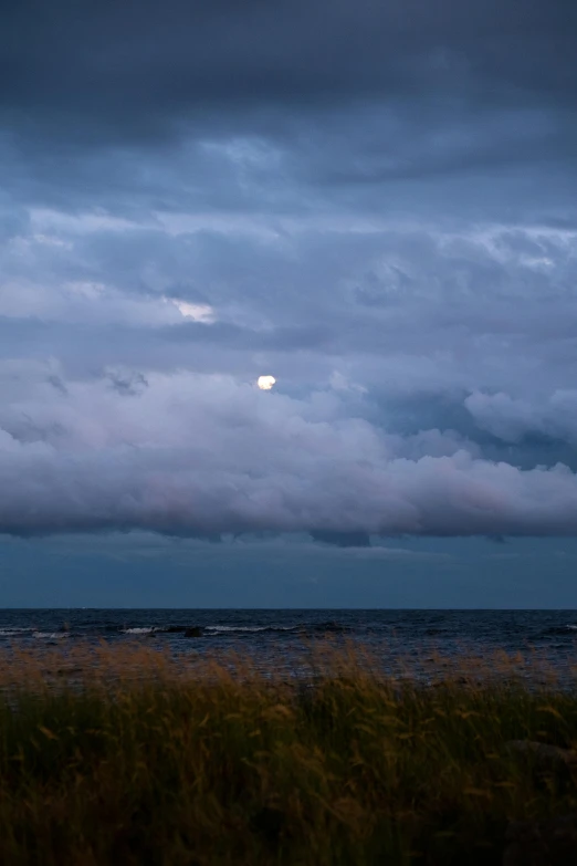 a beautiful blue sunset lights up the sky over the ocean