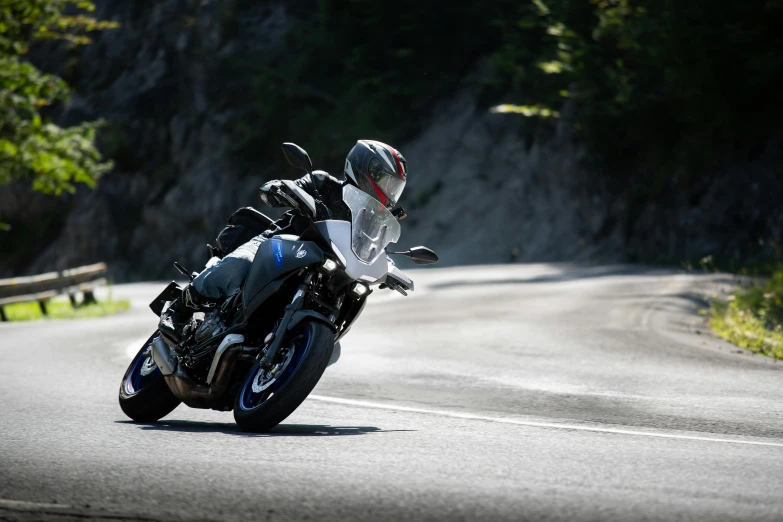 a man riding a motorcycle down a curvy road, square, blue, n9, mount