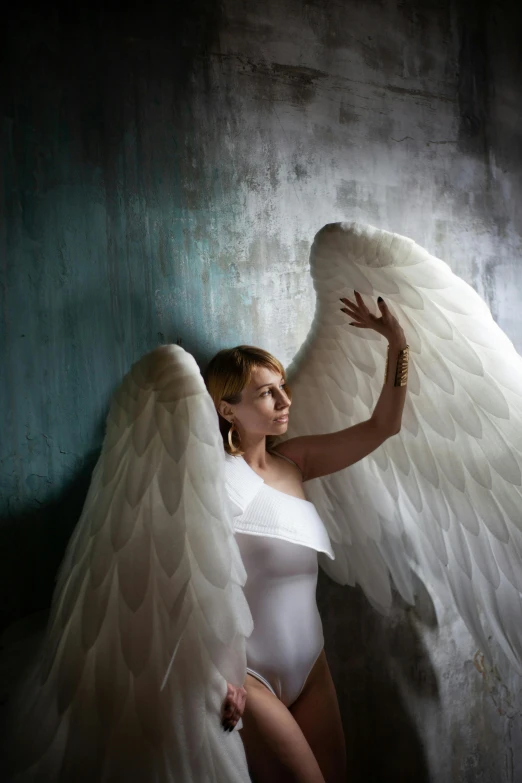 a woman in a white bodysuit with angel wings, inspired by Elsa Bleda, pexels contest winner, renaissance, family photo, ukraine. photography, high, rectangle