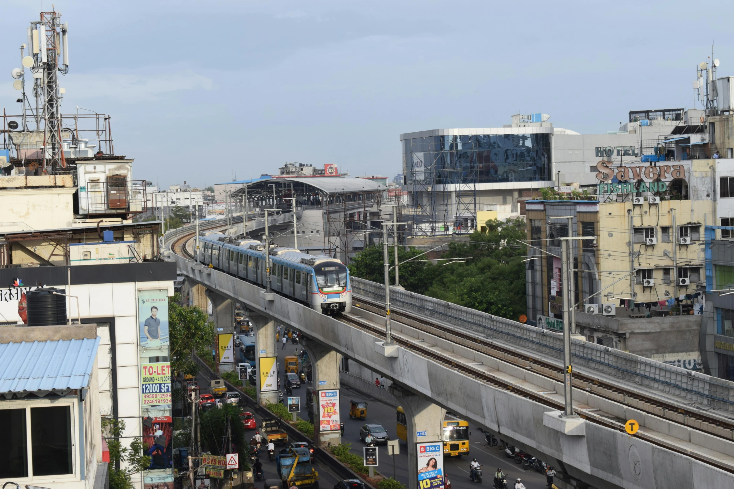 a view of train tracks, buildings and pedestrians