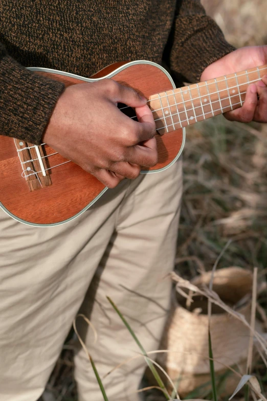 a man playing a guitar in the grass