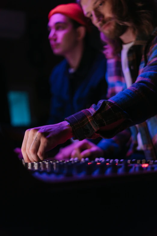 a man that is sitting in front of a keyboard, stage at a club, trending on arts, mixing, university