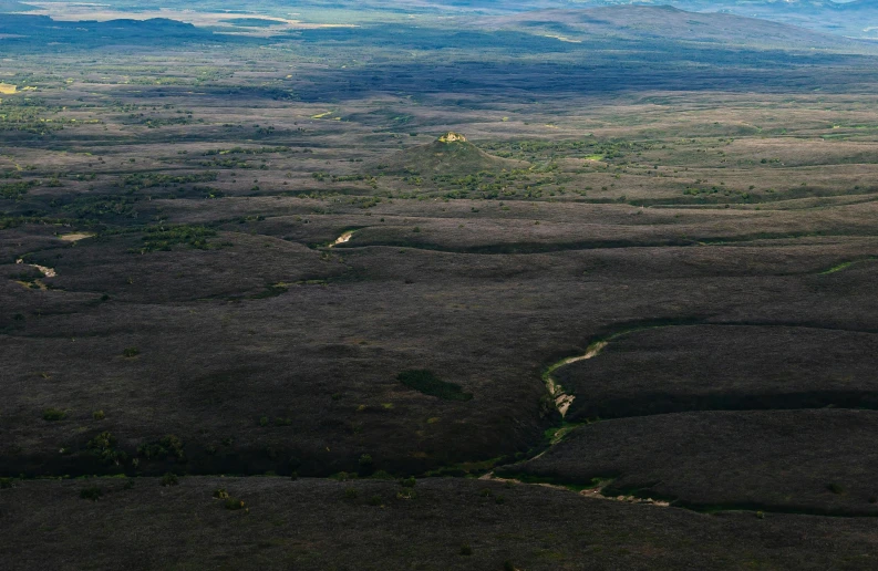 a landscape in the middle of a vast flat, green valley