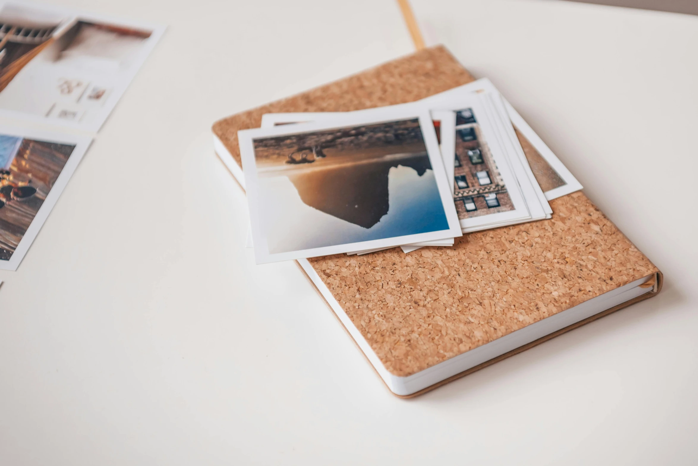 a pile of photos sitting on top of a cork board, a polaroid photo, unsplash, notebook, clean and pristine design, square pictureframes, miniature product photo