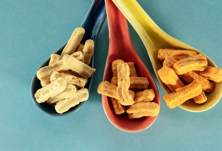 three spoons filled with cereals and dip