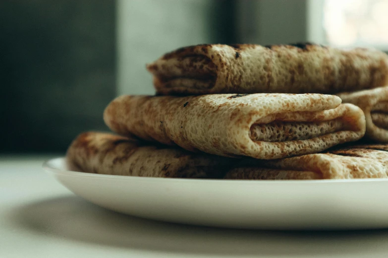 a close up of a plate of food on a table, smokey burnt envelopes, pancake flat head, thumbnail, middle eastern skin