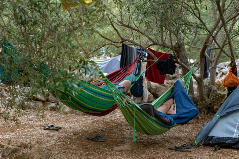 a couple of people that are laying in a hammock, by Simon Marmion, unsplash, mediterranean fisher village, forest picnic, asleep, laundry hanging